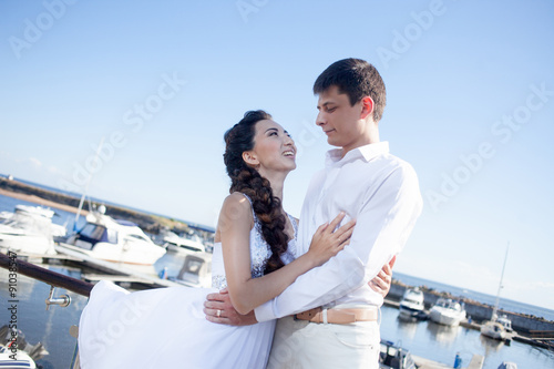 bride and groom on the background of  yacht club, young happy © Ulia Koltyrina