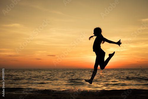 Happy teen girl jumping on the beach
