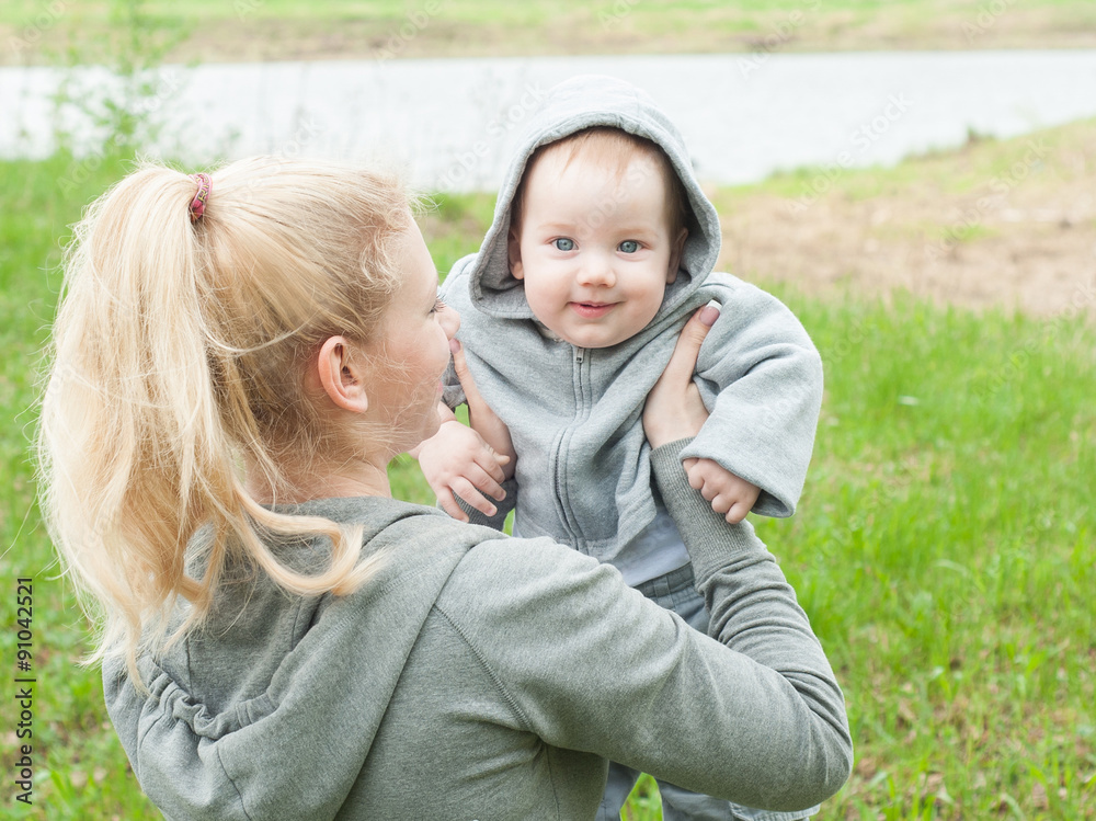 Beautiful Mother And Baby outdoors. Nature. Mum and her Child pl Beautiful Mother And Baby outdoors. Nature. Mum and her Child pl