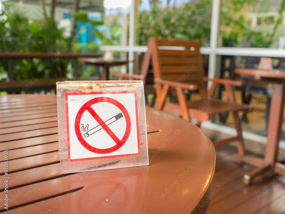 No smoking sign displayed on the wooden table No smoking sign displayed on the wooden table