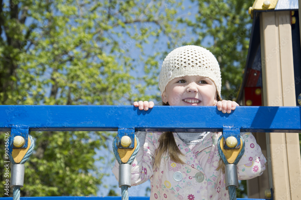 In the spring on the playground playing little girl. In the spring on the playground playing little girl.