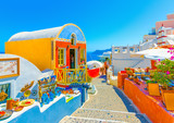 Typical colorful narrow street in Oia the most beautiful village of Santorini island in Greece