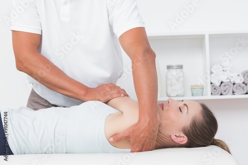 Doctor stretching a young woman back 