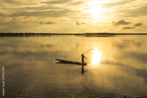 Fishermen are casting a lake at sunset. © EmmaStock