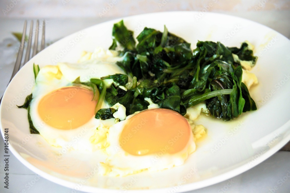 Creamy spinach with fried egg. Healthy breakfast