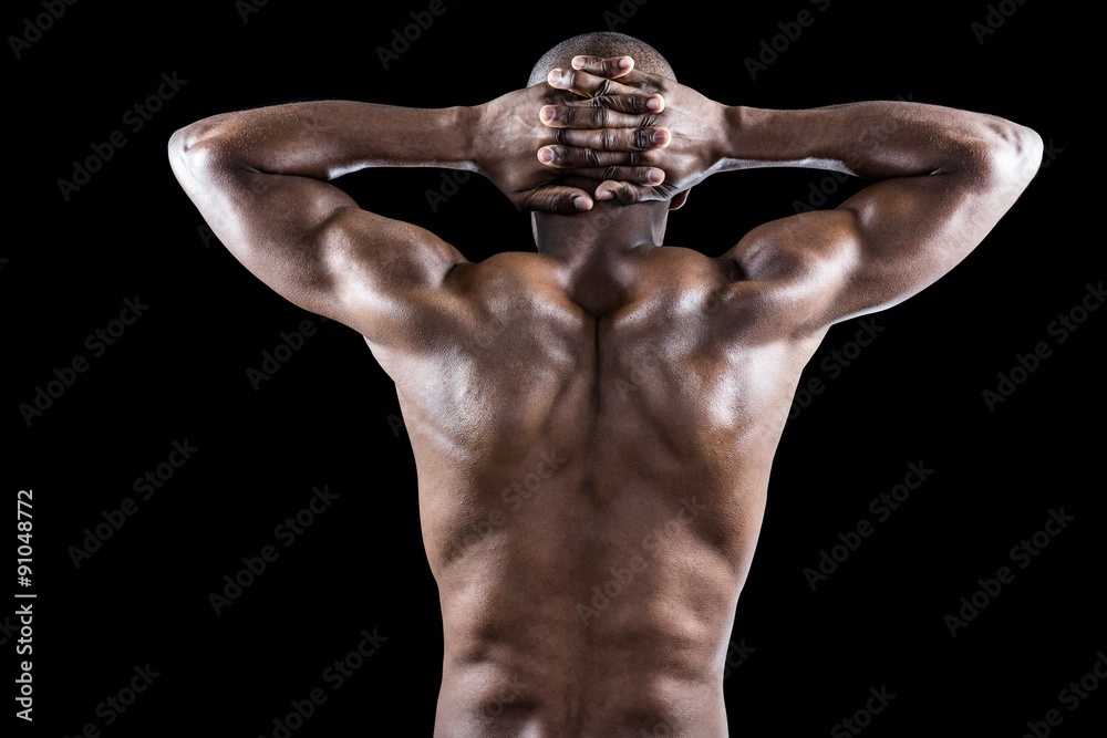 Fototapeta premium Rear view of muscular athlete stretching with hands behind head