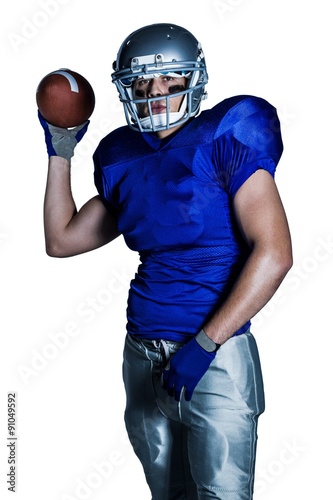 Portrait of American football player in uniform throwing ball