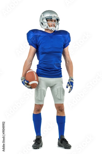 American football player looking away while holding ball
