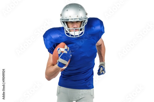 Confident American football player running with ball