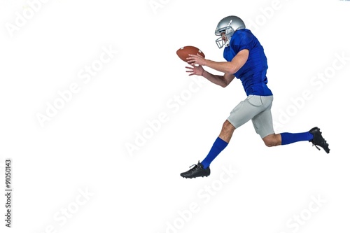American football player running while catching ball © WavebreakmediaMicro