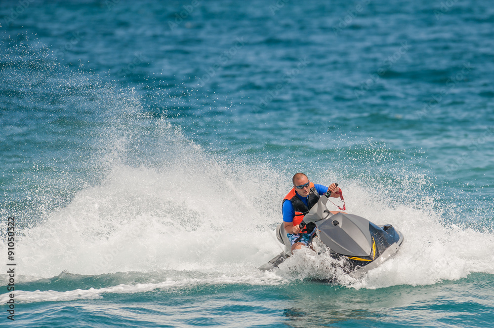 Young Man on Jet Ski, Tropical Ocean, Vacation Concept Young Man on Jet Ski, Tropical Ocean, Vacation Concept