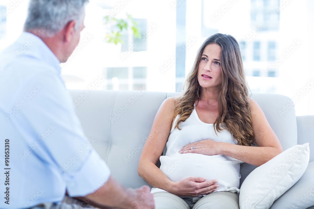Obraz premium Preganant woman talking with therapist at home