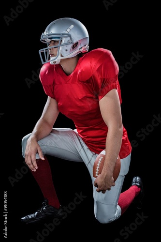 American football player looking away while kneeling