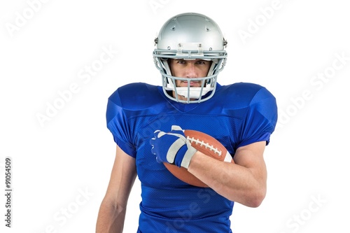 Portrait of American football player holding ball