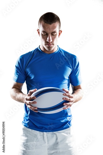 Thoughtful rugby player holding ball