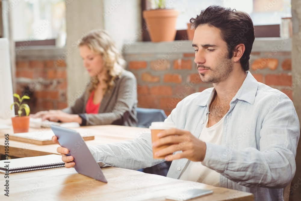 Businessman looking at digital tablet in office Businessman looking at digital tablet in office
