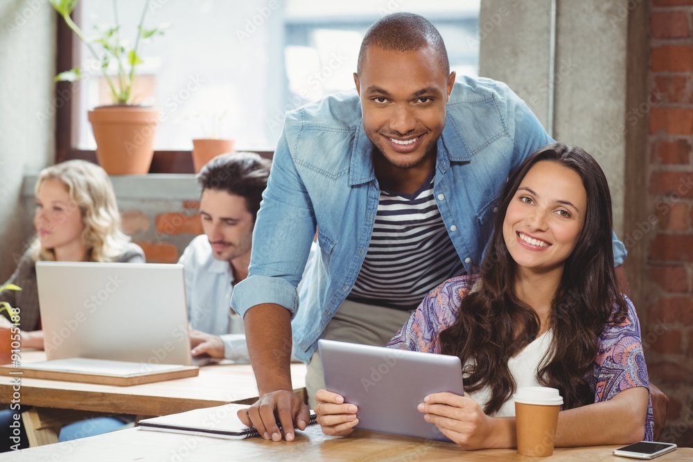 Portrait of smiling colleague with digital tablet in office