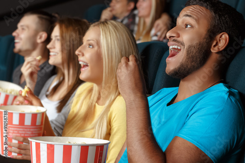 Friends laughing during a movie