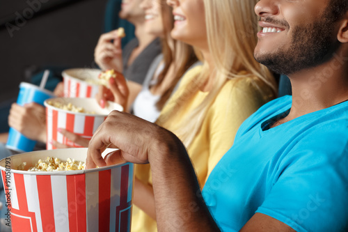 Friends eating popcorn at the movie theatre