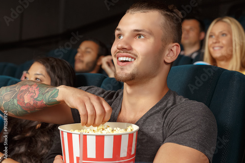 Young man laughing during a comedy film