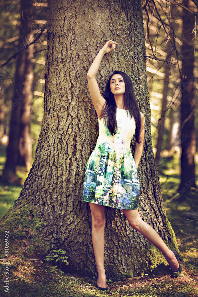 Beautiful young fashion woman in color dress posing outdoor in g Beautiful young fashion woman in color dress posing outdoor in g