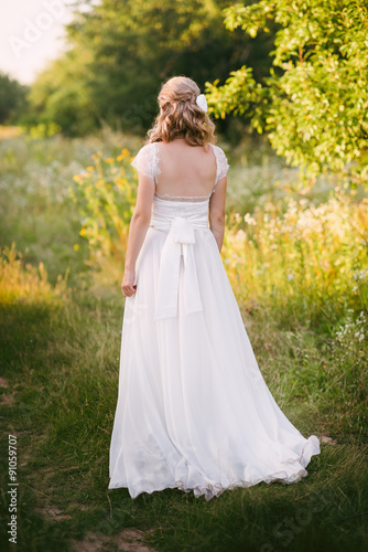 Wallpaper Mural Stylish beautiful blonde bride standing in her wedding dress back to nature in the sunset light, wedding, marriage, tenderness, woman, lifestyle Torontodigital.ca