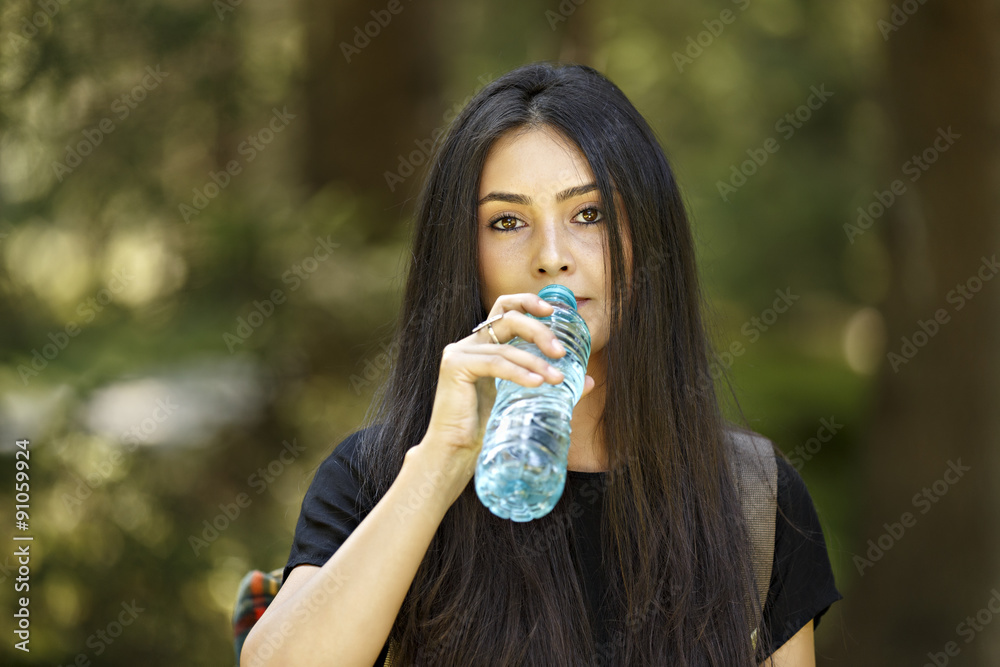 Beautiful young woman tourist in the park. Drink water. Beautiful young woman tourist in the park. Drink water.