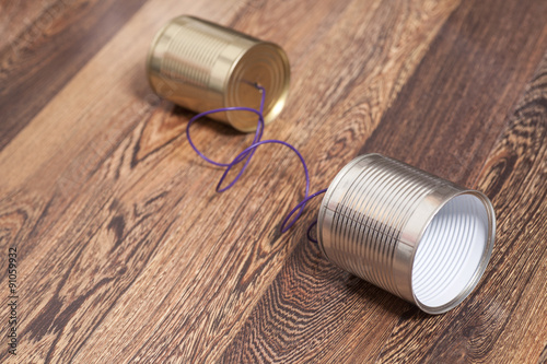 Tin Can Phone Wooden Background.Communication concept