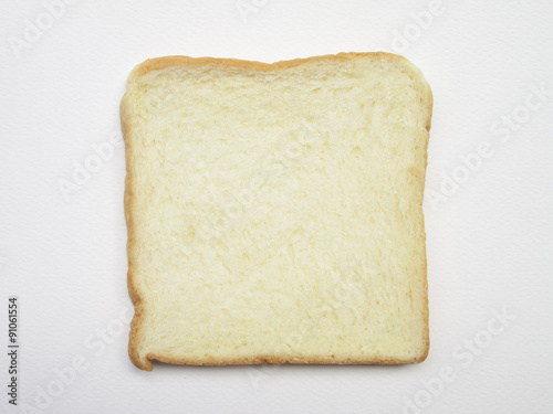 Close-up image of one slice of white bread against the paper white background