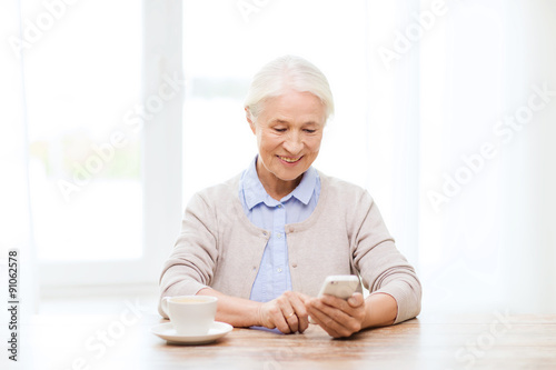 senior woman with smartphone texting at home