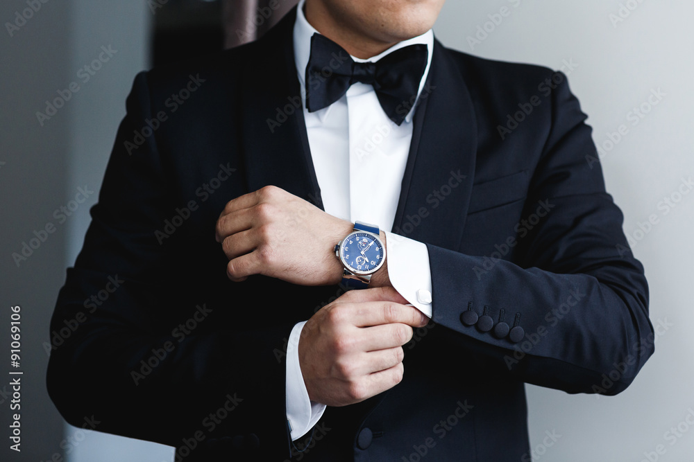 Fotografie the groom puts on a watch