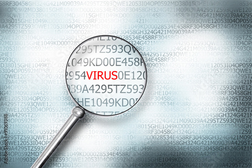 reading the word virus on computer screen with a magnifying glas photo