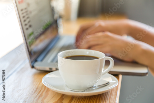 Coffee cup  with laptop on old wooden table