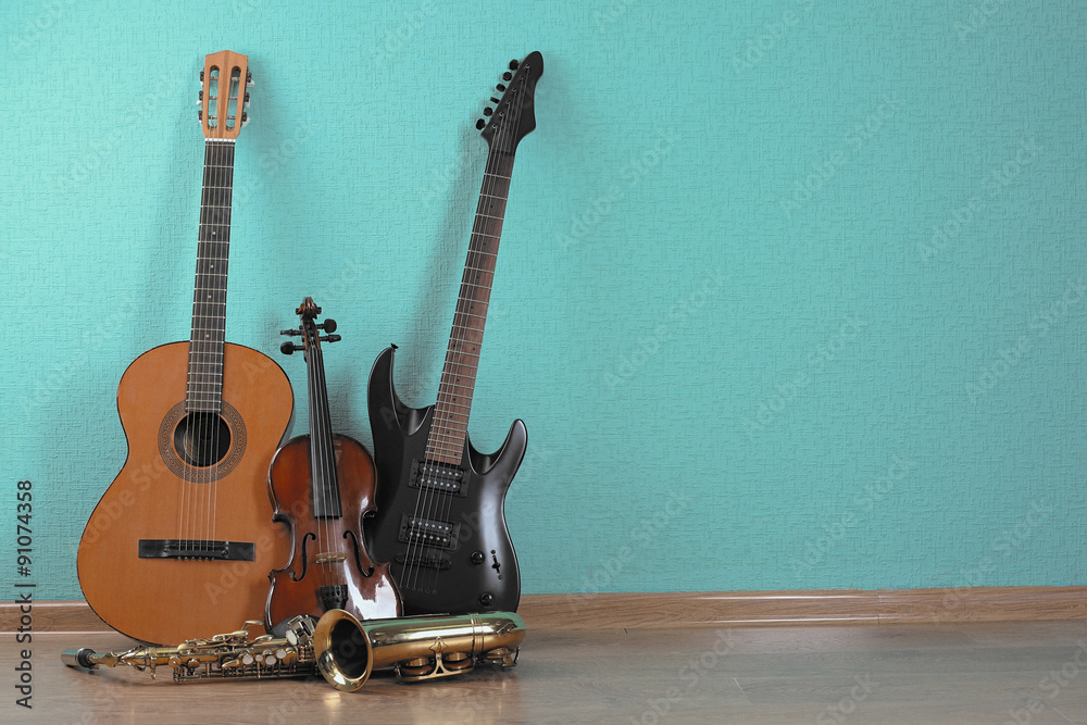 Fototapeta premium Musical instruments on turquoise wallpaper background