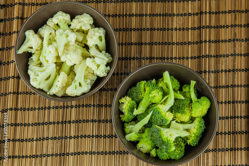 Food preparation on the bowls. The ingredients include fresh green broccolii, and Cauliflower. photo