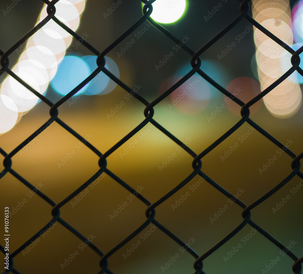 Fototapeta premium night light bokeh road behind grate on blur background