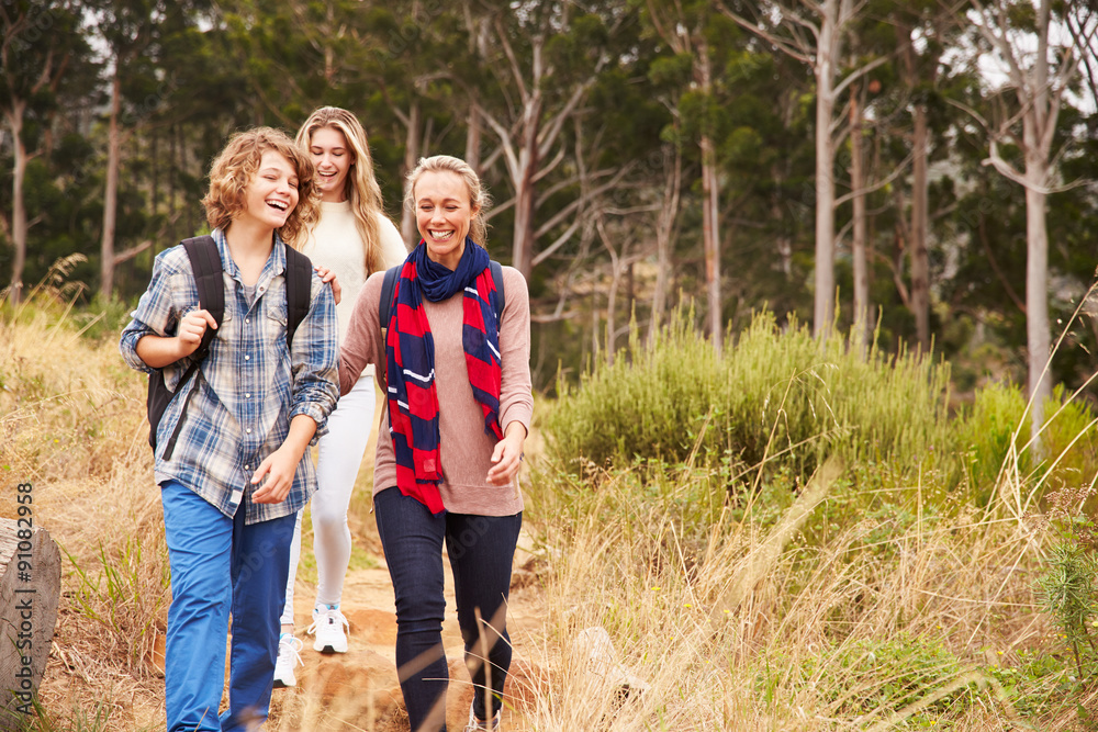 Happy mother and two kids walking in a forest