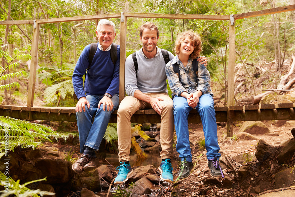 Three generations of men on a bridge in a forest, portrait Three generations of men on a bridge in a forest, portrait