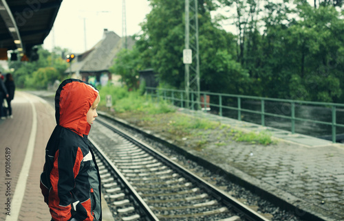 Wallpaper Mural 7 years old boy standing on a railway station and waiting for th Torontodigital.ca