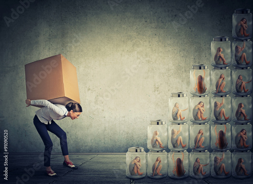 фотографія woman with big box on her back climbing up a stair made of jars with women insid