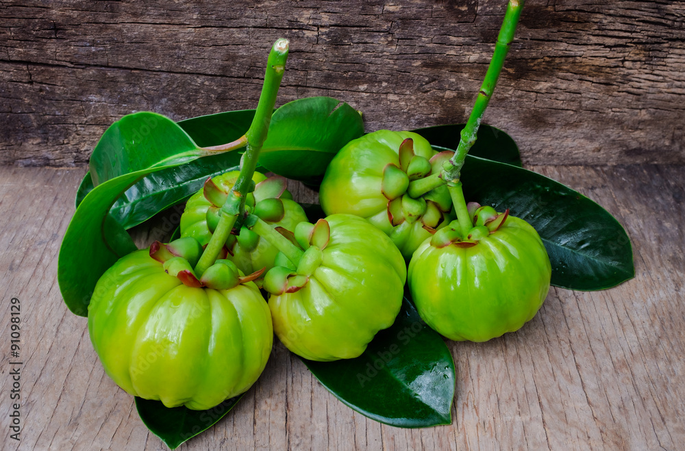 Still life with fresh garcinia cambogia on wooden background