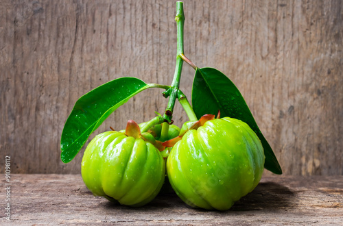 Still life with fresh garcinia cambogia on wooden background  photo