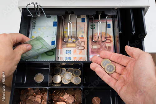 Person Hands With Money Over Cash Register photo