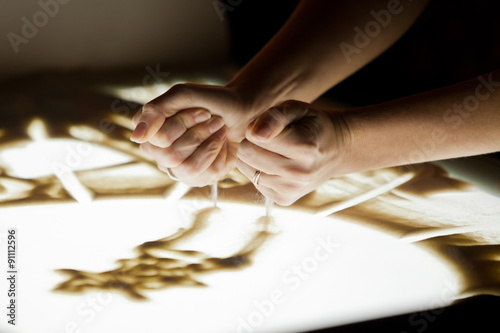  Sand animation.The girl's arms, drawing sand in dark colors