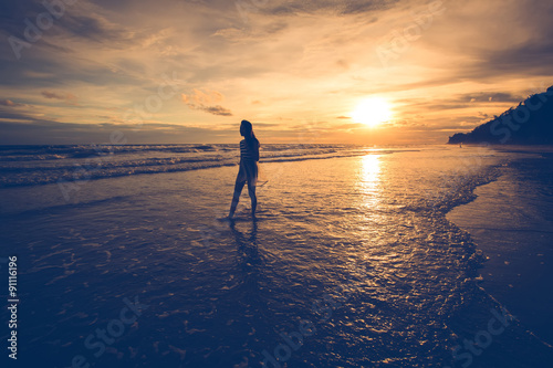 Young woman silhouettes standing on beach at sunset.vintage styl © singto2