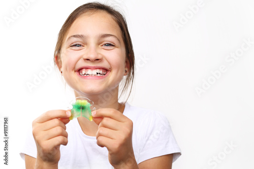 Kolorowy aparat ortodontyczny.Uśmiechnięta dziewczynka z kolorowym aparatem ortodontycznym 