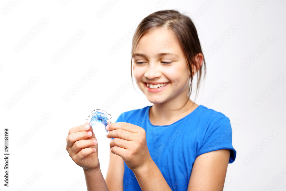 Dziewczynka z kolorowym aparatem ortodontycznym  - obrazy, fototapety, plakaty 