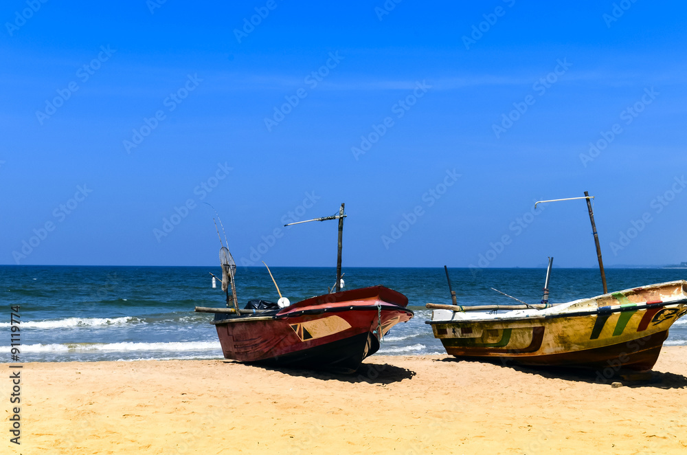 Two fishing boats on the beach by ocean Two fishing boats on the beach by ocean