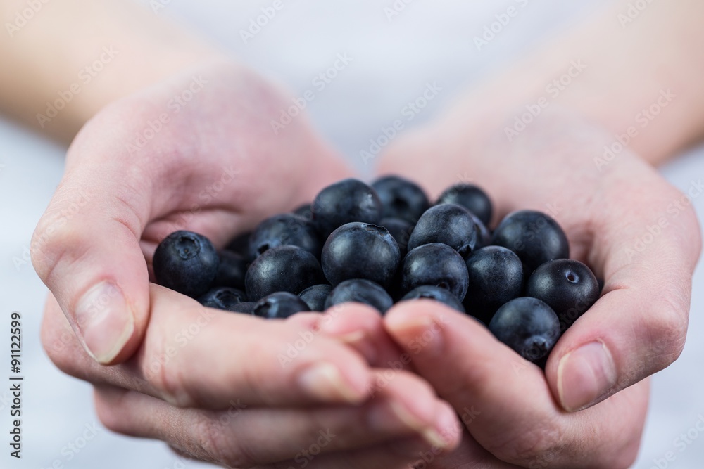 Woman showing handful of blueberries Woman showing handful of blueberries