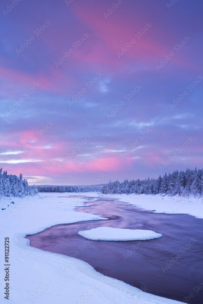 Fototapeta premium Sunrise over river rapids in a winter landscape, Finnish Lapland